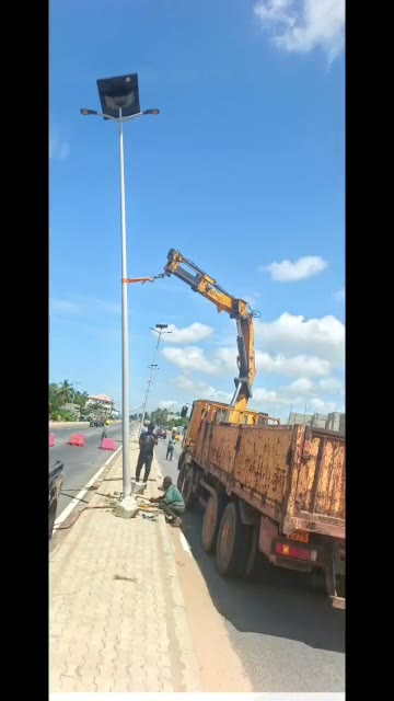 Camion-grue installant un lampadaire solaire